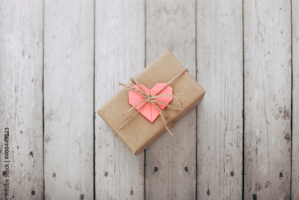 Flat lay Happy Valentine's Day photography with gift box and paper origami heart on wooden background. Romantic greeting card. Flat lay Happy Valentine's Day photography with gift box and paper origami heart on wooden background. Romantic greeting card.