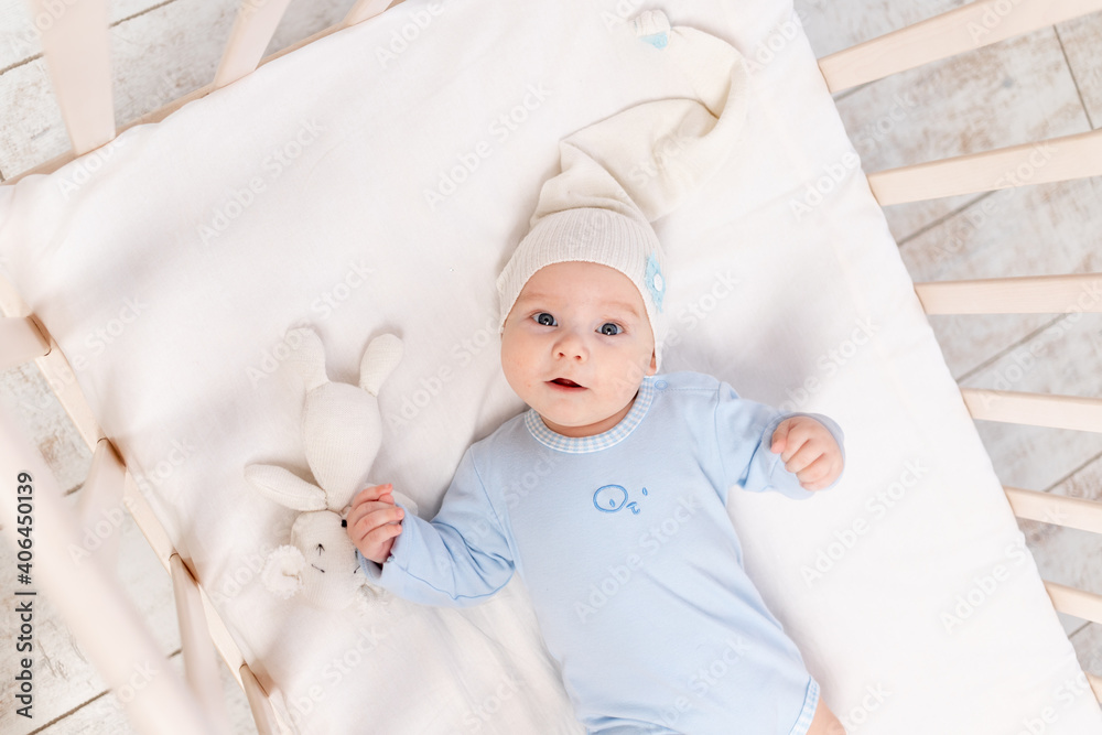 baby in the crib at home in the morning or before going to bed, portrait, family and birth concept baby in the crib at home in the morning or before going to bed, portrait, family and birth concept