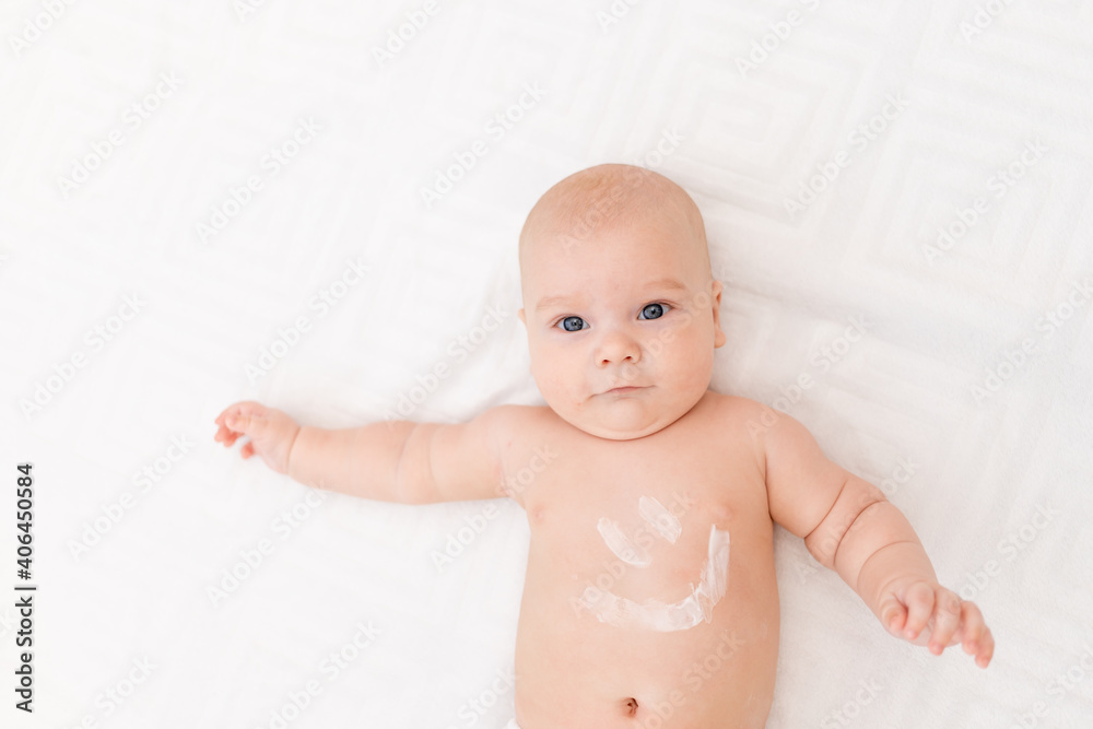 baby with a smile on his stomach on a light background baby with a smile on his stomach on a light background