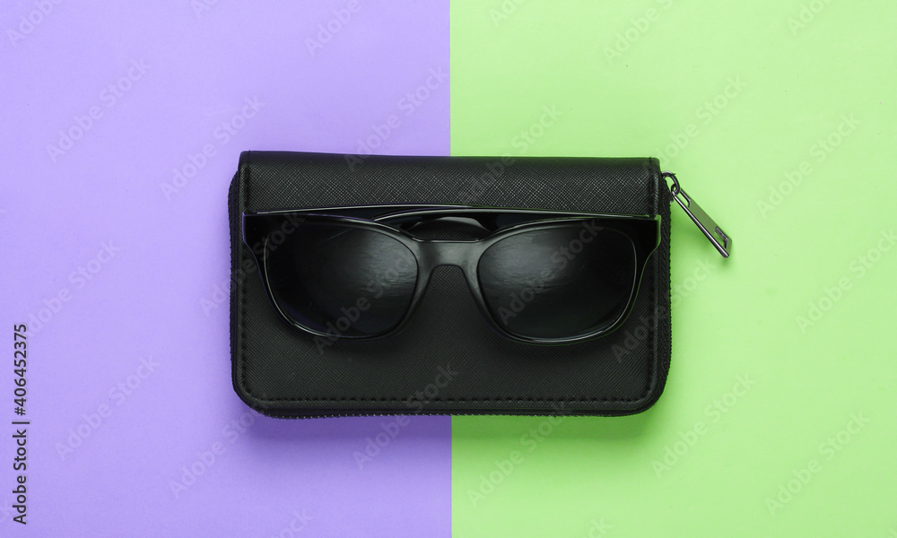 Wallet with sunglasses on colored background. Women's accessories. Top view Wallet with sunglasses on colored background. Women's accessories. Top view