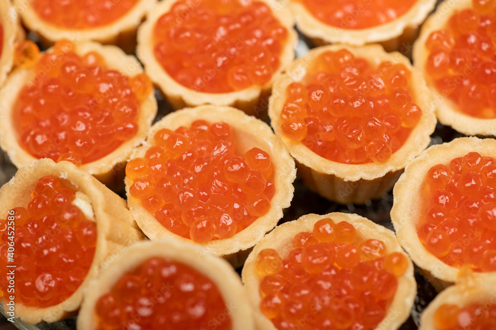 Tartlets with salmon caviar on a platter. Close-up, selective focus. Tartlets with salmon caviar on a platter. Close-up, selective focus.