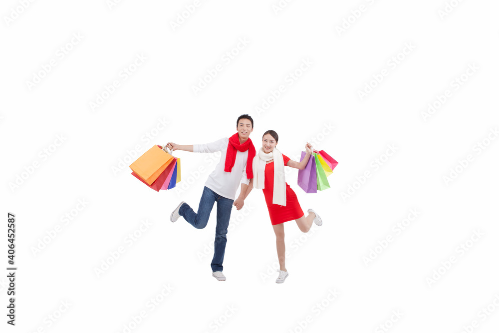 Portrait of young couple holding shopping bags,opening arms Portrait of young couple holding shopping bags,opening arms