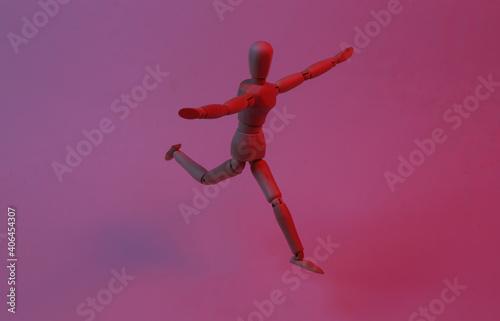 Happy wooden puppet mannequin in red blue neon light.