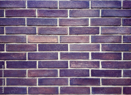 Old dark red brick wall with lots of textures and colors.