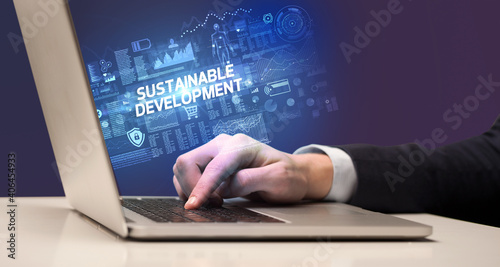Businessman working on laptop with SUSTAINABLE DEVELOPMENT inscription, cyber technology concept