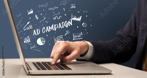 Businessman working on laptop with AD CAMPAIGN inscription, modern business concept