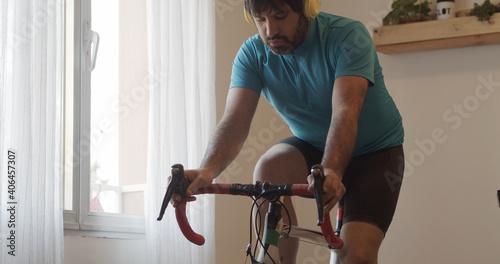 Konstfotografi Man doing exercise bike at home while listening to music