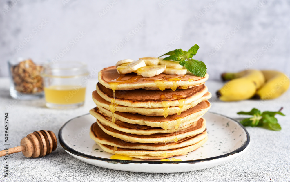 Homemade pancakes with banana, honey and mint on the kitchen table. Homemade pancakes with banana, honey and mint on the kitchen table.