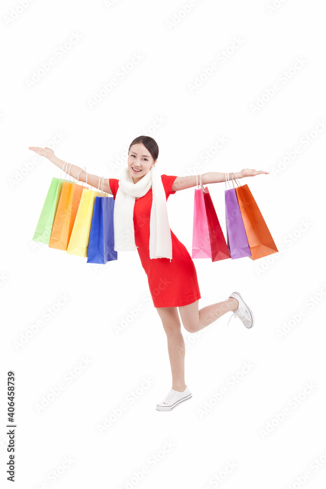 Portrait of young woman holding up shopping bags,opening arms Portrait of young woman holding up shopping bags,opening arms