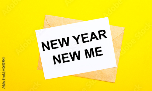 On a yellow background, an envelope and a card with the text NEW YEAR NEW MY. View from above