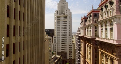 Aerial view in middle of buildings towards the Farol Santander, Banespa Tower, sunny day, in Sao Paulo, Brazil - rising, drone shot photo