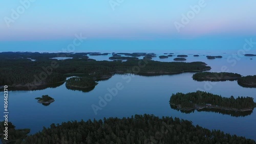 Aerial view over islands, during a vibrant dawn, in the archipelago of Finland - reverse, drone shot photo