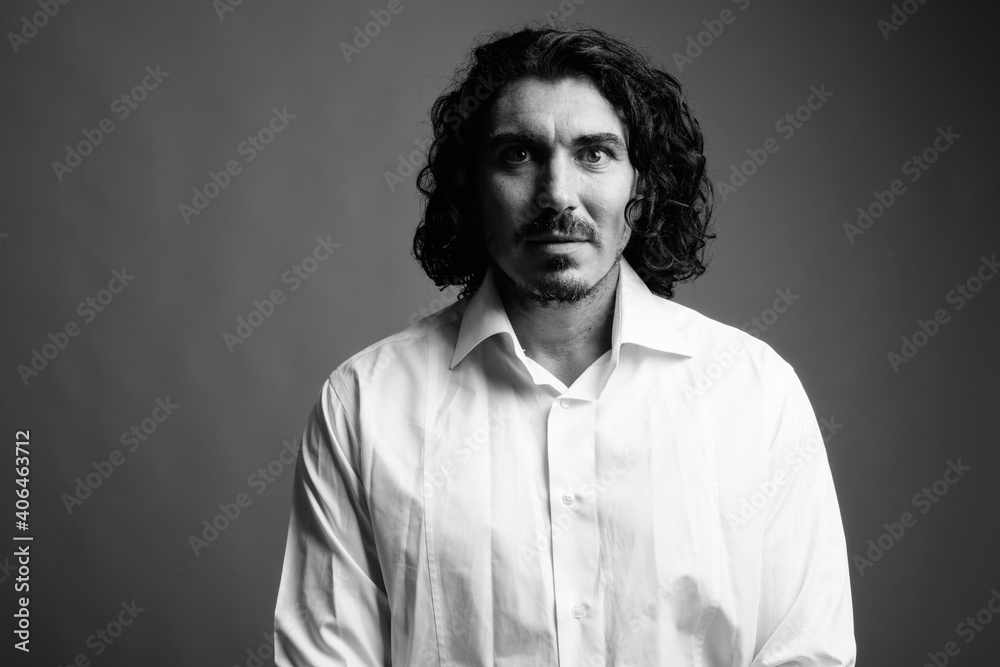 Handsome businessman with mustache against gray background
