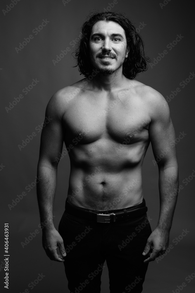 Muscular handsome man with mustache shirtless against gray background Muscular handsome man with mustache shirtless against gray background