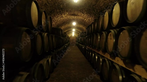 Worker in wine , whiskey or brandy warehouse sorting and rotating barrel . Traditional wine factory rolls barrel . Shot making by drone. 4k. Ukraine