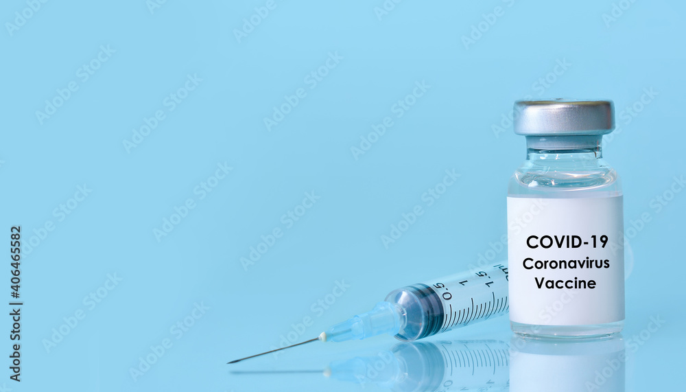 Vaccine in a bottle with a syringe on a blue background.The concept of medicine, healthcare and science.Coronavirus vaccine.Copy space for text.Banner Vaccine in a bottle with a syringe on a blue background.The concept of medicine, healthcare and science.Coronavirus vaccine.Copy space for text.Banner