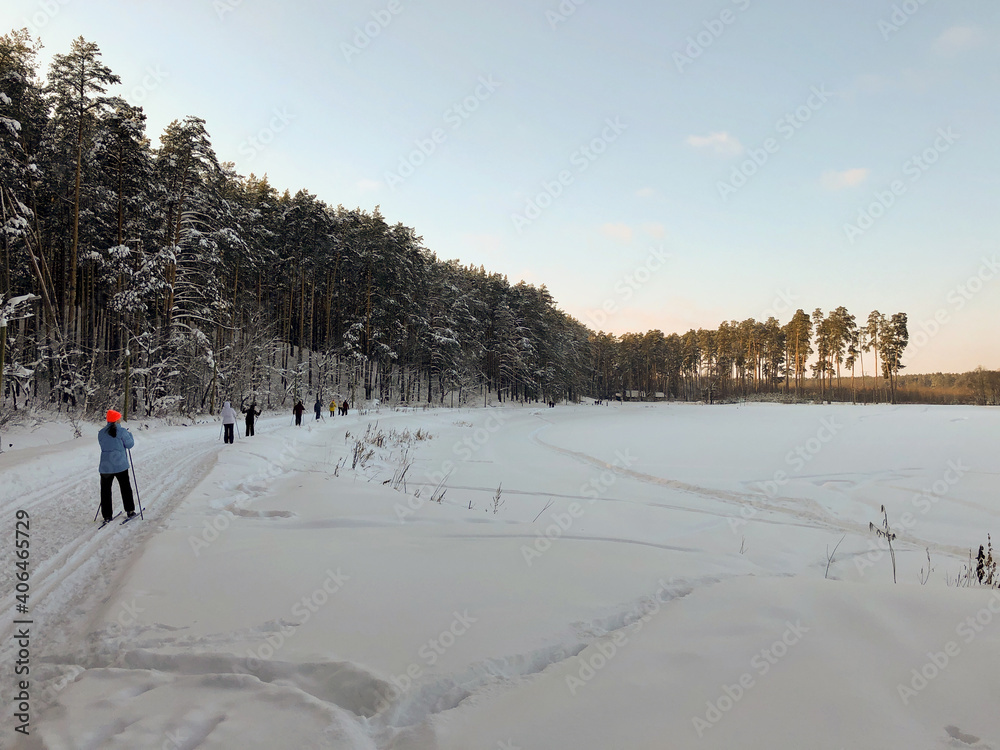 Winter landscape: skiers ride along a frozen lake