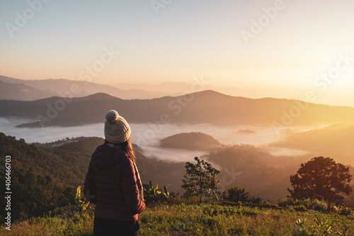 Young woman travelers looking at the sunrise and the sea of mist on the mountain in the morning, Travel lifestyle concept