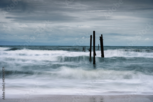 Wave hitting decay wooden bridge on the beach in stormy © Mumemories