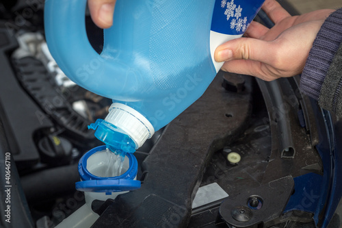 adding winter windscreen washer fluid in the car photo