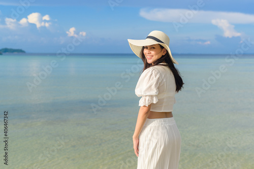 A happy beautiful woman in white dress enjoying and relaxing on the beach, Summer and holidays concept