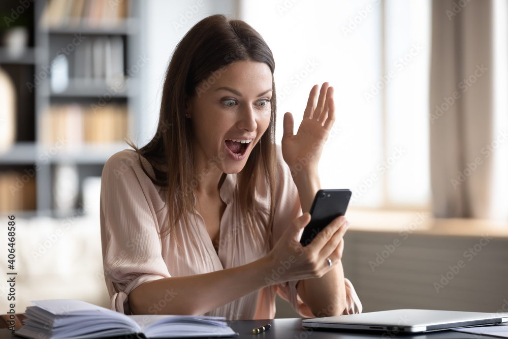 Close up shocked young woman with wide open eyes and mouth looking at phone screen, reading unexpected news in email or message, excited by money refund, great shopping offer, job promotion Close up shocked young woman with wide open eyes and mouth looking at phone screen, reading unexpected news in email or message, excited by money refund, great shopping offer, job promotion