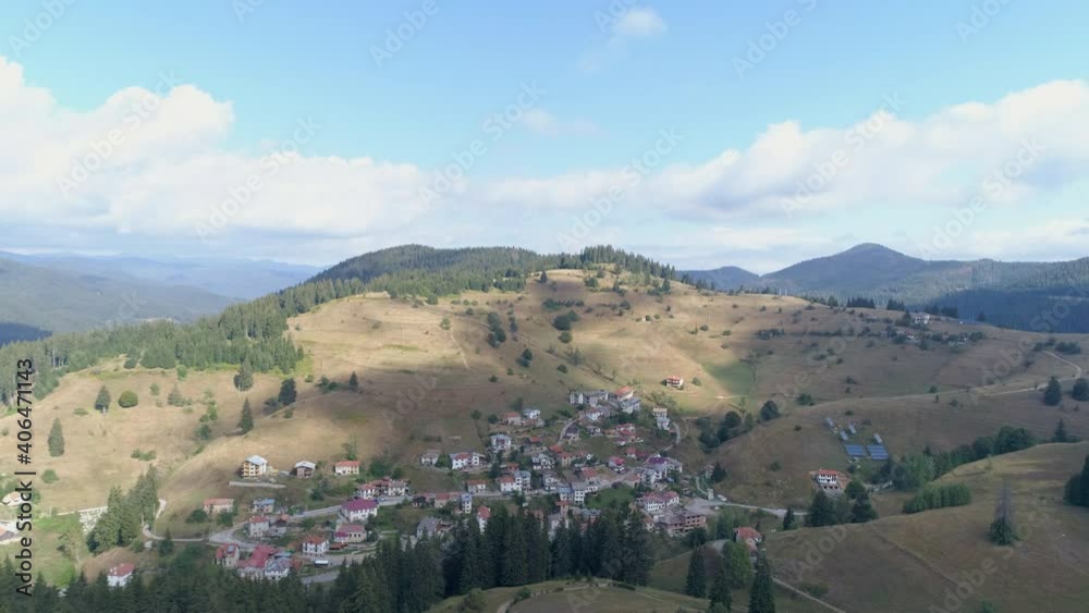 AERIAL: a small village in a valley between hills. AERIAL: a small village in a valley between hills.