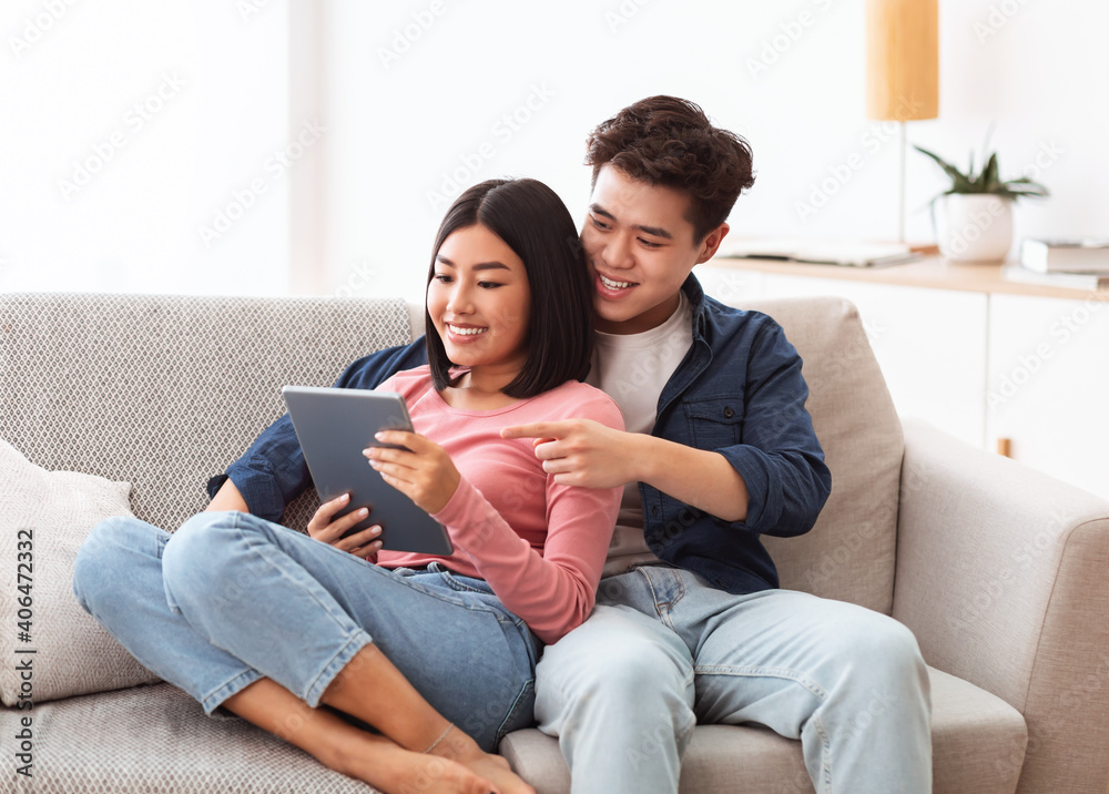 Happy Asian Spouses Browsing Internet On Digital Tablet At Home Happy Asian Spouses Browsing Internet On Digital Tablet At Home