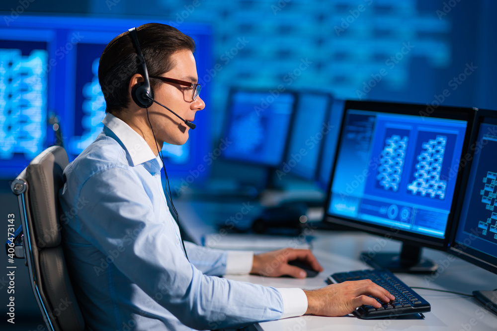 Call-center worker is speaking with the client by headset. Workplace of the professional support operator in office. Call-center worker is speaking with the client by headset. Workplace of the professional support operator in office.