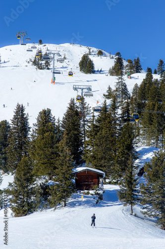 Cable cars travel up the ski mountain on a beautiful sunny day