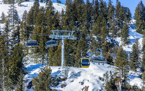 Ski lifts taking people to the top of a mountin in full sun