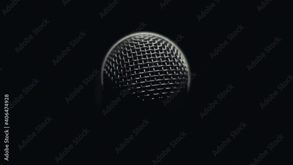 Light slowly rotating around microphone in darkness