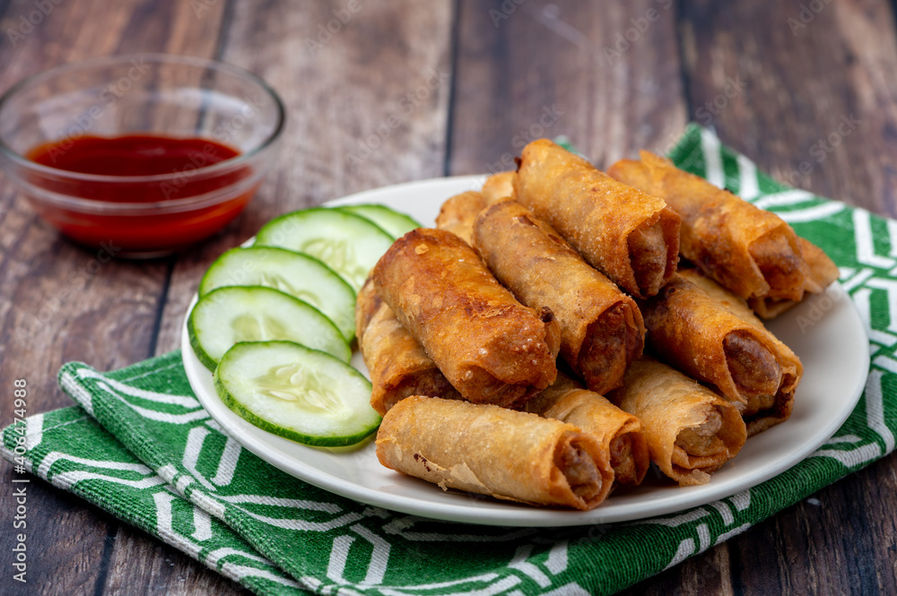 Pork Lumpiang Shanghai (side shot with place mat and sauce) is a Filipino favorite, its a dish usually served at parties and feasts. This is very similar to a spring roll.

