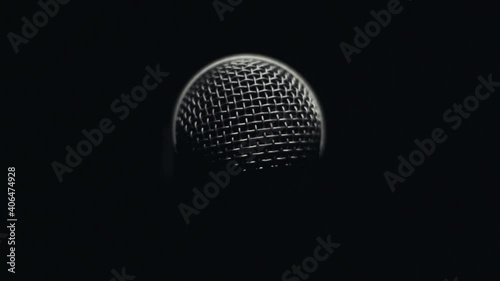 Light slowly rotating around microphone in darkness