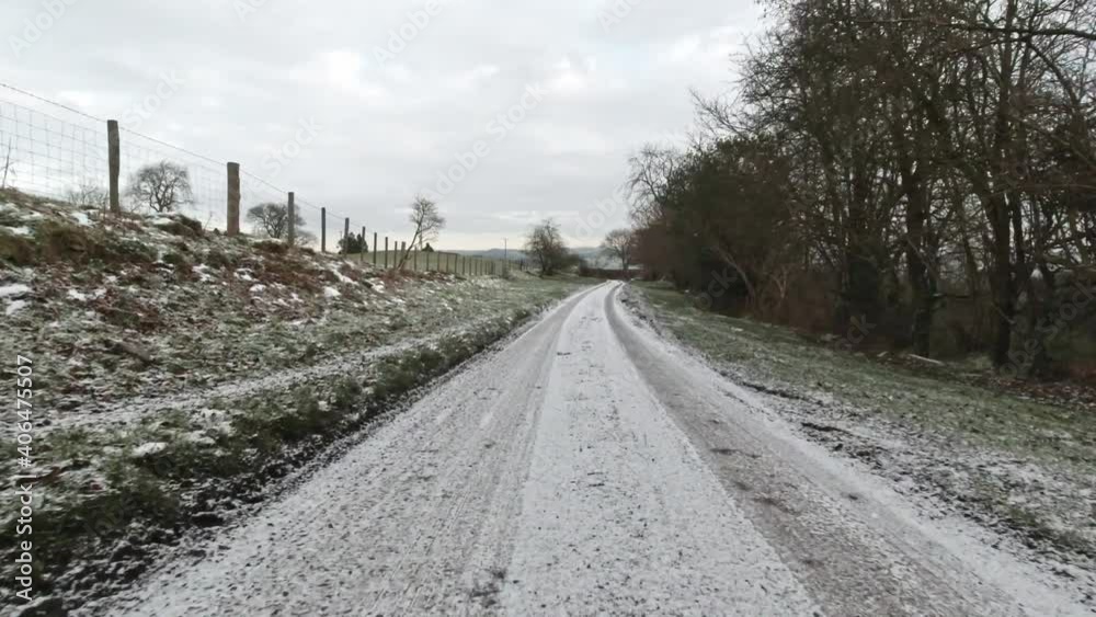 Driving snowy rural country frozen road in slippery winter conditions on frosty morning Driving snowy rural country frozen road in slippery winter conditions on frosty morning