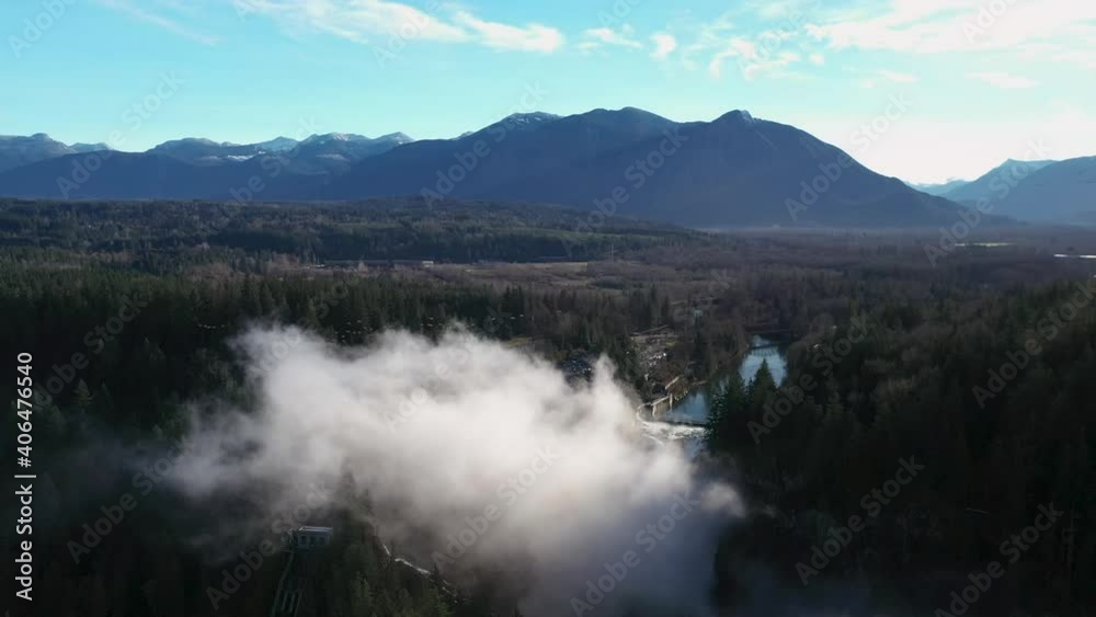 Beautiful landscape showing Snoqualmie Waterfall and River with rural woodland in background and mountains during sunlight in America. Aerial circling footage. Beautiful landscape showing Snoqualmie Waterfall and River with rural woodland in background and mountains during sunlight in America. Aerial circling footage.