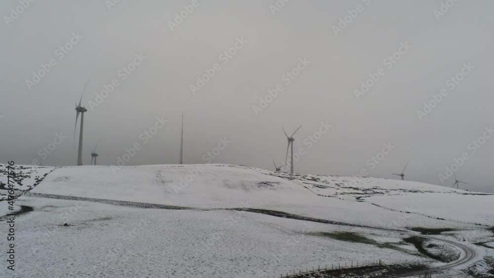 Winter mountain countryside wind turbines on rural highlands aerial view cold snowy weather low orbit left Winter mountain countryside wind turbines on rural highlands aerial view cold snowy weather low orbit left