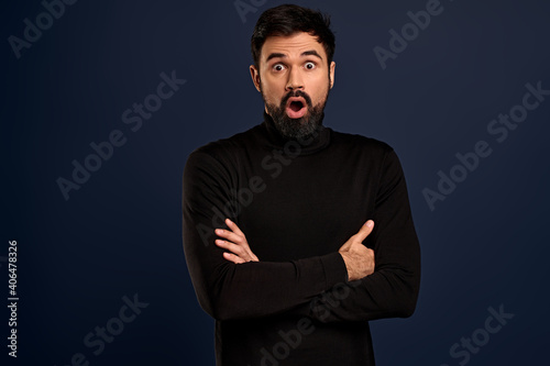 Surprised, fascinated handsome businessman hear interesting news, open mouth say wow and stare camera amused, cross arms over chest, look curious, think idea is good, Pacific Blue background