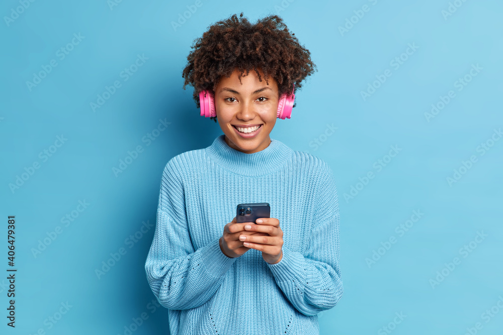 Beautiful dark skinned millennial girl uses modern smartphone sends Beautiful dark skinned millennial girl uses modern smartphone sends