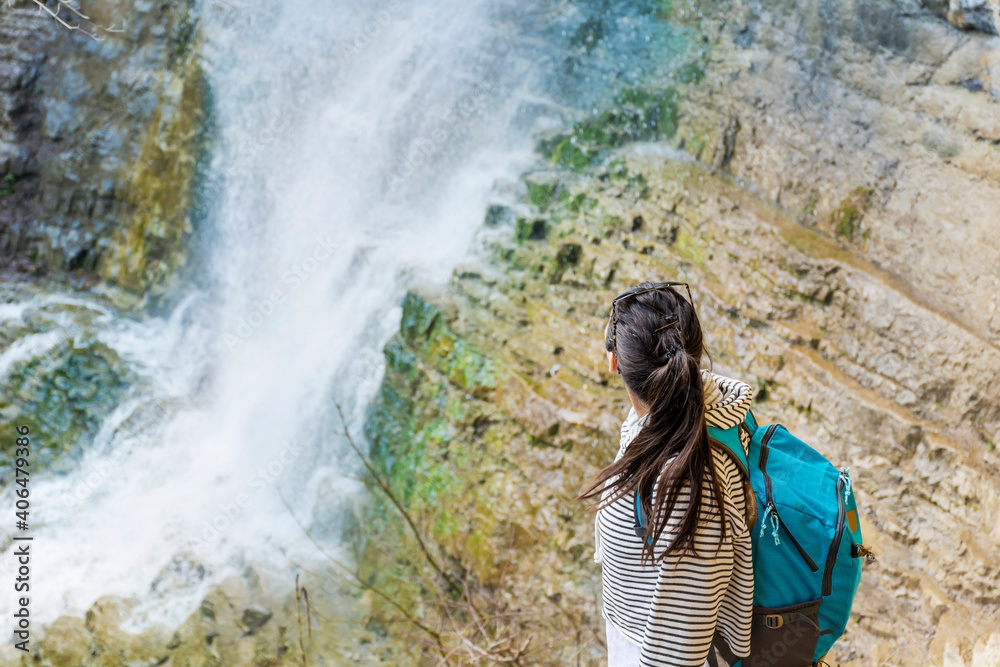Young Tourist Woman in the  Mountain Looking a Spring Waterfall