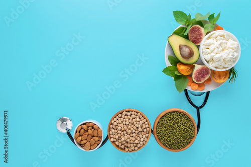 Concept of medical diet, healthy food, balanced products. Food and stethoscope on a blue background with copy space.