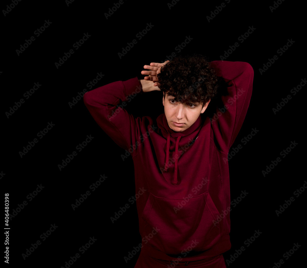 Attractive young man with curly hair posing on black studio background Attractive young man with curly hair posing on black studio background