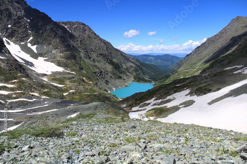 Alpine lake Kuiguk in a mountain Altai gorge in summer  top view. Blue lake in the high-mountain valley  summer sunny day  rocky mountain slopes  in some places there is snow