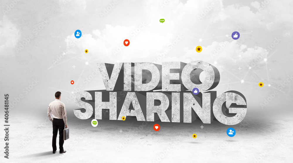 Young businessman standing in front of VIDEO SHARING inscription, social media concept
