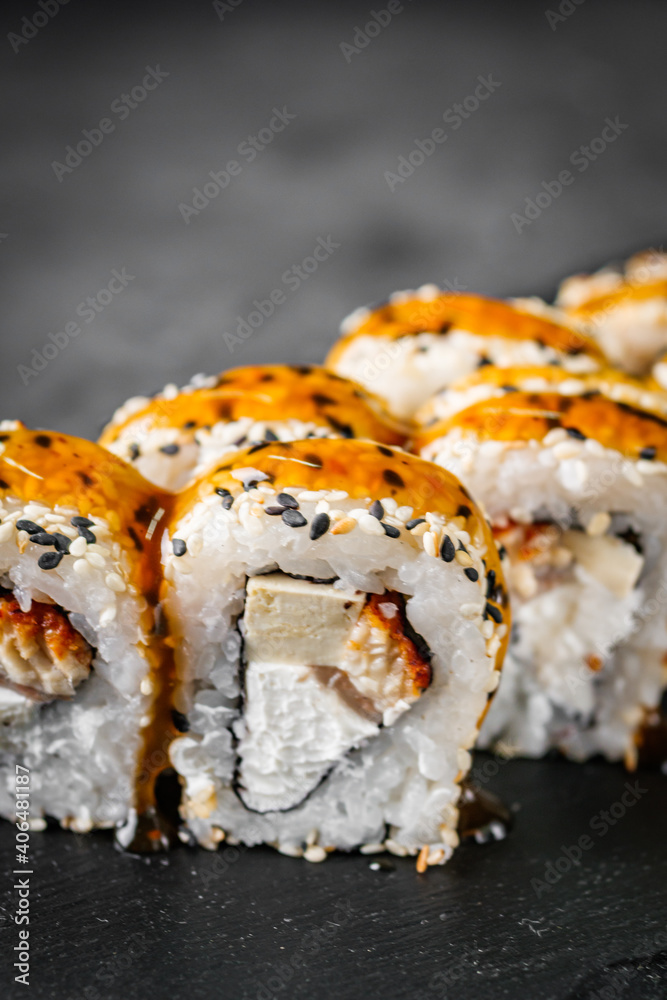 appetizing sushi roll california with eel tofu sesame and unagi cheese on a black stone plate appetizing sushi roll california with eel tofu sesame and unagi cheese on a black stone plate