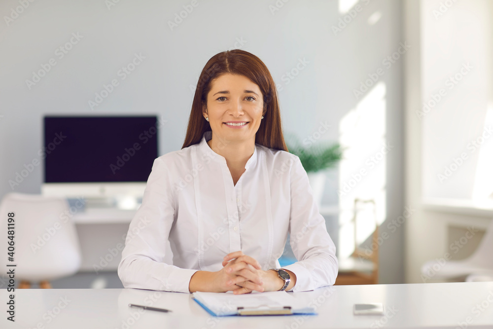 Online business training. Young business woman consults on a video call sitting at a table in a bright office. Business, education, office, greeting concept. Woman at work. Webcam view.