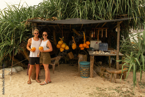 young couple buying coconuts at a beach in Sri Lanka