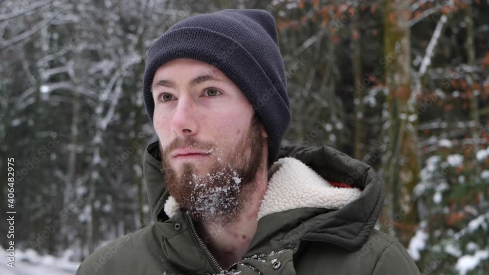 Young Caucasian man gets hit by a snowball in the face and beard and smiles. Young Caucasian man gets hit by a snowball in the face and beard and smiles.