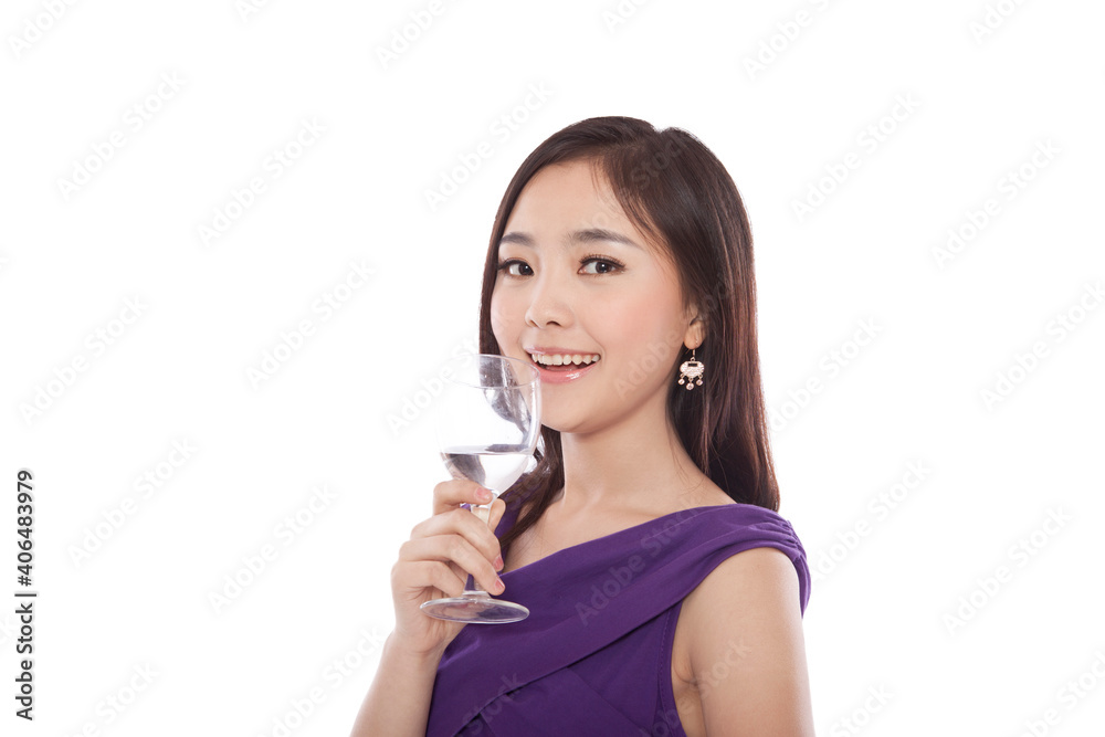 Young woman standing holding glass of water Young woman standing holding glass of water