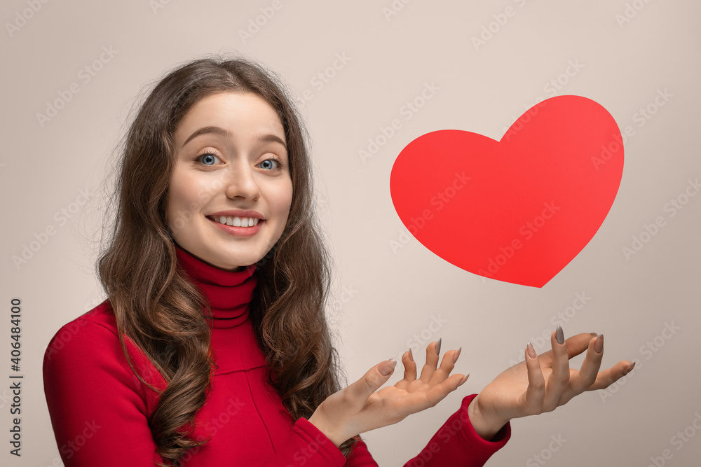 Girl with red cardboard heart, heart hanging in the air Girl with red cardboard heart, heart hanging in the air